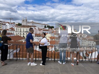 Tourists are seen observing the historic center of the city from Das Portas do Sol viewpoint. Lisbon, June 24, 2022.  (