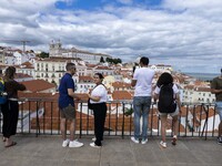 Tourists are seen observing the historic center of the city from Das Portas do Sol viewpoint. Lisbon, June 24, 2022.  (