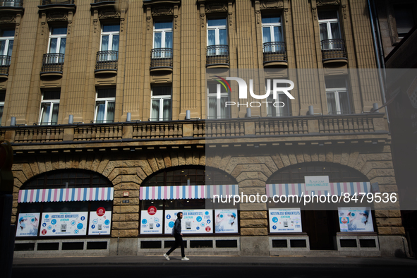 a man walks pass a coronavirus test center in Cologne, Germany on July 1, 2022 as most people Germany will have to pay for covid test from J...