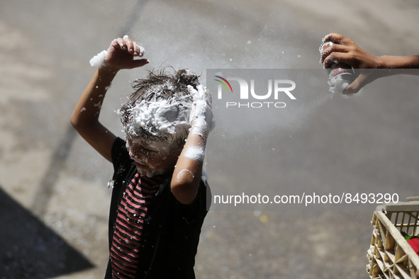 A Palestinian boy  sprays soap on his brother during last day in their final high school exams, known as ''Tawjihi'', in Gaza city on July 0...