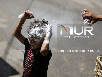 A Palestinian boy  sprays soap on his brother during last day in their final high school exams, known as ''Tawjihi'', in Gaza city on July 0...