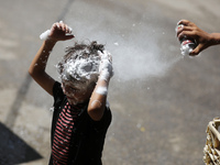 A Palestinian boy  sprays soap on his brother during last day in their final high school exams, known as ''Tawjihi'', in Gaza city on July 0...