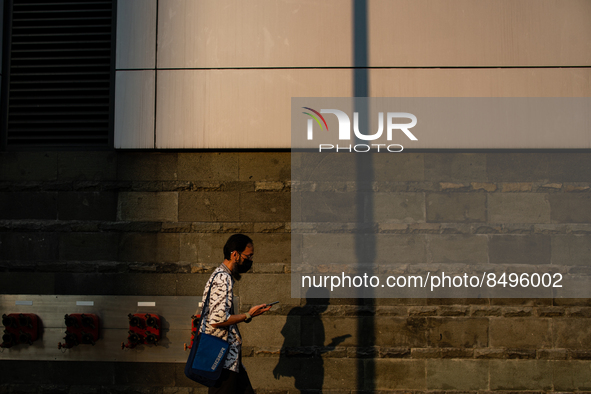 A man wear protective face masks while walking at pedestrian in Jakarta on 5 July 2022. The Indonesian government on Tuesday, July 5, raised...