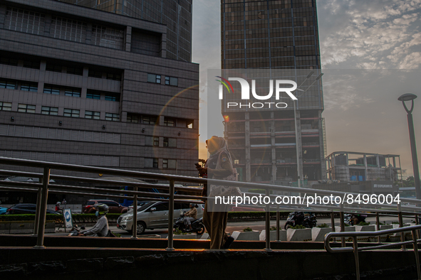 A woman wear protective face masks while walking at pedestrian in Jakarta on 5 July 2022. The Indonesian government on Tuesday, July 5, rais...