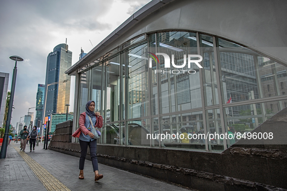 A woman wear protective face masks while walking at pedestrian in Jakarta on 5 July 2022. The Indonesian government on Tuesday, July 5, rais...