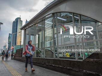 A woman wear protective face masks while walking at pedestrian in Jakarta on 5 July 2022. The Indonesian government on Tuesday, July 5, rais...