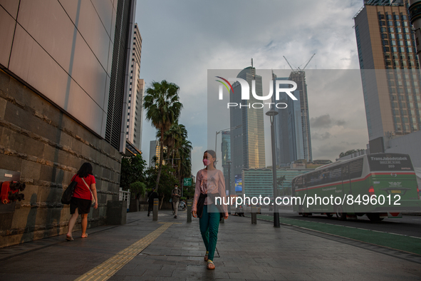 A woman wear protective face masks while walking at pedestrian in Jakarta on 5 July 2022. The Indonesian government on Tuesday, July 5, rais...