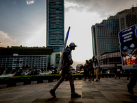 A man carries a walking billboard while walking at pedestrian in Jakarta on 5 July 2022. The Indonesian government on Tuesday, July 5, raise...