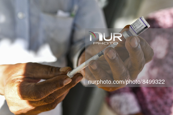 A health worker prepares a Booster Dose of the Pfizer vaccine during vaccination campaign outside of the cattle market at Daulatkhan, Bhola,...