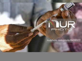 A health worker prepares a Booster Dose of the Pfizer vaccine during vaccination campaign outside of the cattle market at Daulatkhan, Bhola,...