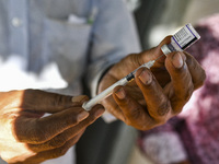 A health worker prepares a Booster Dose of the Pfizer vaccine during vaccination campaign outside of the cattle market at Daulatkhan, Bhola,...