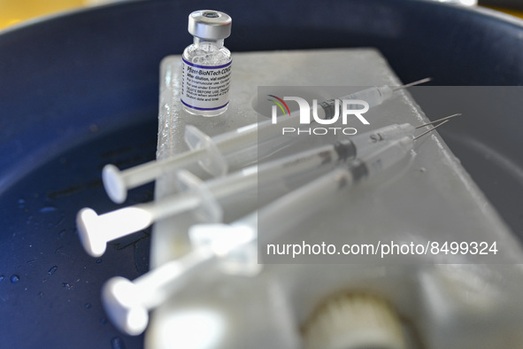 A health worker prepares a Booster Dose of the Pfizer vaccine during vaccination campaign outside of the cattle market at Daulatkhan, Bhola,...