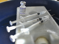 A health worker prepares a Booster Dose of the Pfizer vaccine during vaccination campaign outside of the cattle market at Daulatkhan, Bhola,...