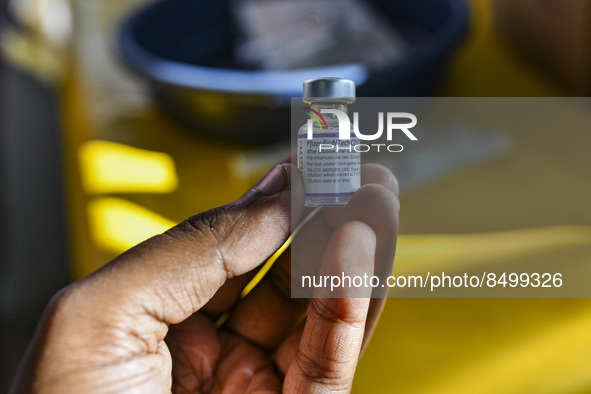 A health person hold a dose of Pfizer COVID-19 vaccine are seen during a vaccination campaign outside of the cattle market at Daulatkhan, Bh...