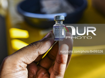 A health person hold a dose of Pfizer COVID-19 vaccine are seen during a vaccination campaign outside of the cattle market at Daulatkhan, Bh...