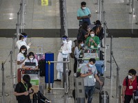 Travellers waiting in line for shuttle bus to quarantine hotels inside Hong Kong International Airport on July 7, 2022 in Hong Kong, China....