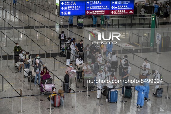 Travellers waiting in line for shuttle bus to quarantine hotels inside Hong Kong International Airport on July 7, 2022 in Hong Kong, China....