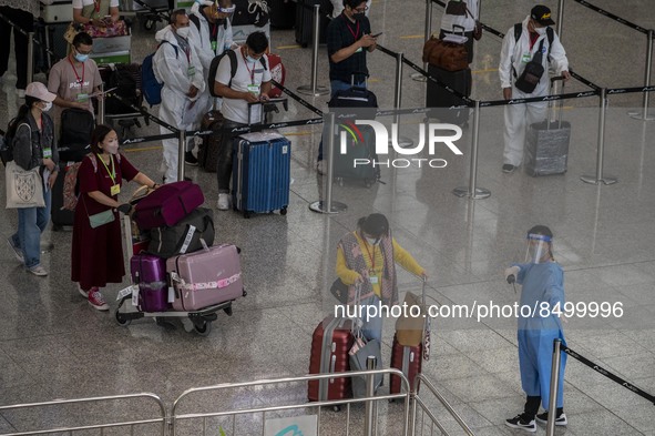 Travellers waiting in line for shuttle bus to quarantine hotels inside Hong Kong International Airport on July 7, 2022 in Hong Kong, China....