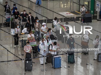 Travellers waiting in line for shuttle bus to quarantine hotels inside Hong Kong International Airport on July 7, 2022 in Hong Kong, China....