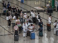 Travellers waiting in line for shuttle bus to quarantine hotels inside Hong Kong International Airport on July 7, 2022 in Hong Kong, China....