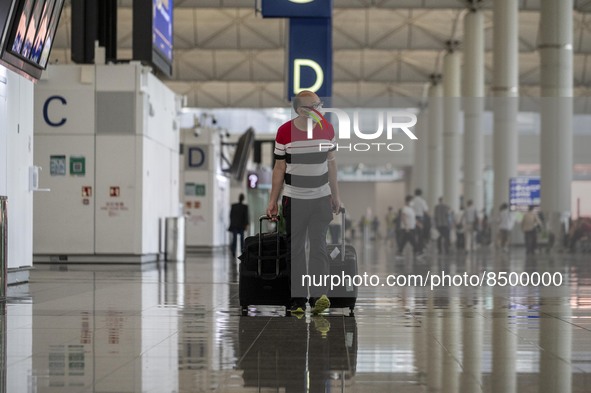 A Man pulling two luggage bag inside Hong Kong International Airport on July 7, 2022 in Hong Kong, China. The Hong Kong Government announce...