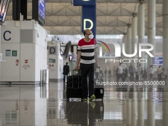 A Man pulling two luggage bag inside Hong Kong International Airport on July 7, 2022 in Hong Kong, China. The Hong Kong Government announce...