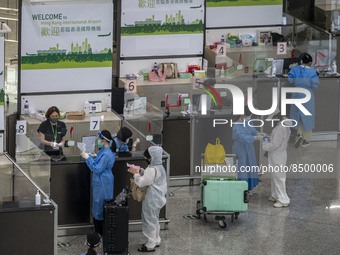 Travellers sanding at a booth inside Hong Kong International Airport on July 7, 2022 in Hong Kong, China. The Hong Kong Government announce...