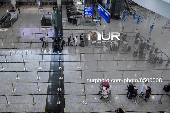 Travellers waiting in line for shuttle bus to quarantine hotels inside Hong Kong International Airport on July 7, 2022 in Hong Kong, China....