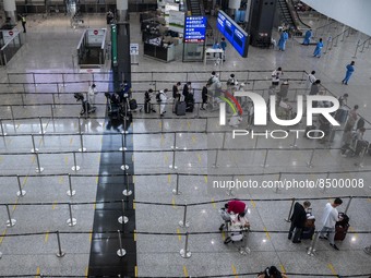 Travellers waiting in line for shuttle bus to quarantine hotels inside Hong Kong International Airport on July 7, 2022 in Hong Kong, China....