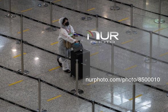 A women wear a PPE pushing a luggage inside Hong Kong International Airport on July 7, 2022 in Hong Kong, China. The Hong Kong Government an...