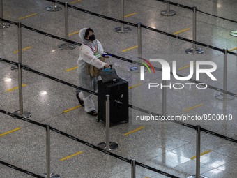 A women wear a PPE pushing a luggage inside Hong Kong International Airport on July 7, 2022 in Hong Kong, China. The Hong Kong Government an...