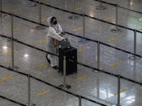 A women wear a PPE pushing a luggage inside Hong Kong International Airport on July 7, 2022 in Hong Kong, China. The Hong Kong Government an...