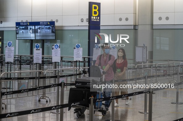 Travellers pushing luggage trolley after arrive in Hong Kong inside Hong Kong International Airport on July 7, 2022 in Hong Kong, China. The...