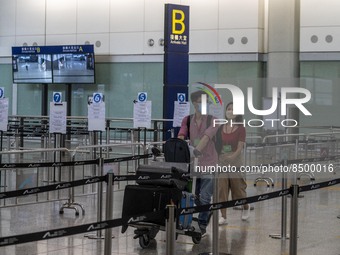 Travellers pushing luggage trolley after arrive in Hong Kong inside Hong Kong International Airport on July 7, 2022 in Hong Kong, China. The...