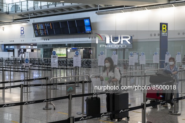 Travellers pushing luggage trolley after arrive in Hong Kong inside Hong Kong International Airport on July 7, 2022 in Hong Kong, China. The...