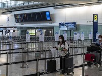 Travellers pushing luggage trolley after arrive in Hong Kong inside Hong Kong International Airport on July 7, 2022 in Hong Kong, China. The...