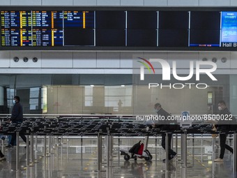 Travellers walk pass a flight arrival display board inside Hong Kong International Airport on July 7, 2022 in Hong Kong, China. The Hong Kon...