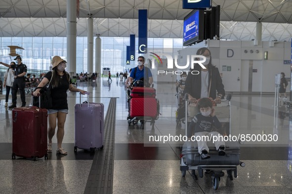 Travellers pushing luggage inside Hong Kong International Airport on July 7, 2022 in Hong Kong, China. The Hong Kong Government announce tha...