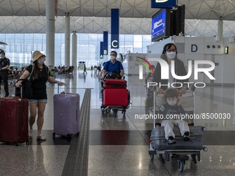 Travellers pushing luggage inside Hong Kong International Airport on July 7, 2022 in Hong Kong, China. The Hong Kong Government announce tha...