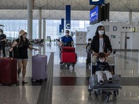 Travellers pushing luggage inside Hong Kong International Airport on July 7, 2022 in Hong Kong, China. The Hong Kong Government announce tha...