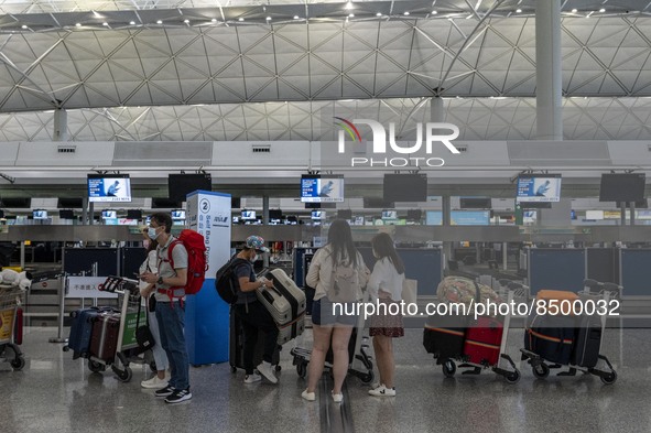 Travellers lining up at a check in counter inside Hong Kong International Airport on July 7, 2022 in Hong Kong, China. The Hong Kong Governm...