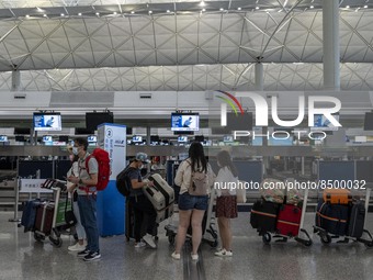 Travellers lining up at a check in counter inside Hong Kong International Airport on July 7, 2022 in Hong Kong, China. The Hong Kong Governm...