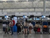 Travellers lining up at a check in counter inside Hong Kong International Airport on July 7, 2022 in Hong Kong, China. The Hong Kong Governm...