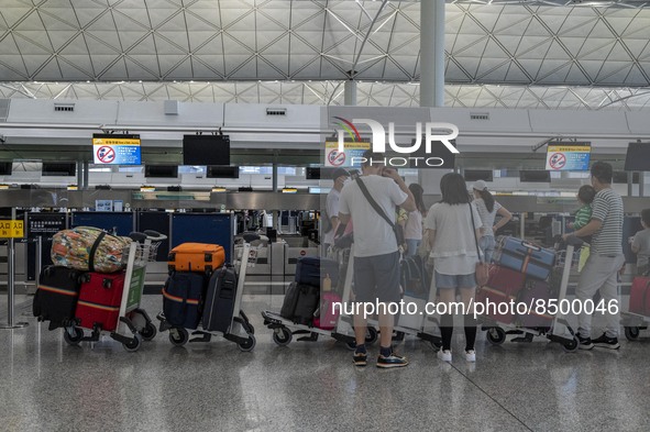 Travellers lining up at a check in counter inside Hong Kong International Airport on July 7, 2022 in Hong Kong, China. The Hong Kong Governm...