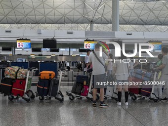 Travellers lining up at a check in counter inside Hong Kong International Airport on July 7, 2022 in Hong Kong, China. The Hong Kong Governm...