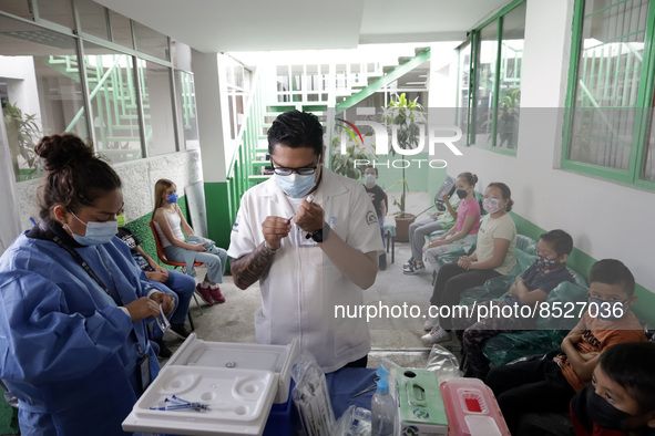  A health worker prepares a Pfizer's Covid19 dose during a mass vaccination campaign for  children under 9 years of age  to prevent infectio...