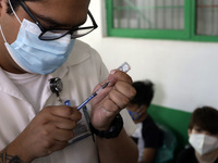  A health worker prepares a Pfizer's Covid19 dose during a mass vaccination campaign for  children under 9 years of age  to prevent infectio...