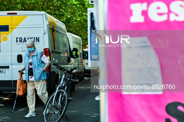 A woman with a face mask walks by the tent. France sees a resurgence of Covid19 cases. Many people come to get tested in  Clermont-Ferrand,...