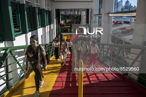 People wearing face masks walking up the pier after exiting the Star Ferry on July 12, 2022 in Hong Kong, China. The Hong Kong Government an...