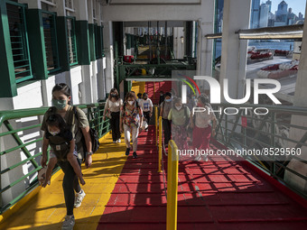 People wearing face masks walking up the pier after exiting the Star Ferry on July 12, 2022 in Hong Kong, China. The Hong Kong Government an...